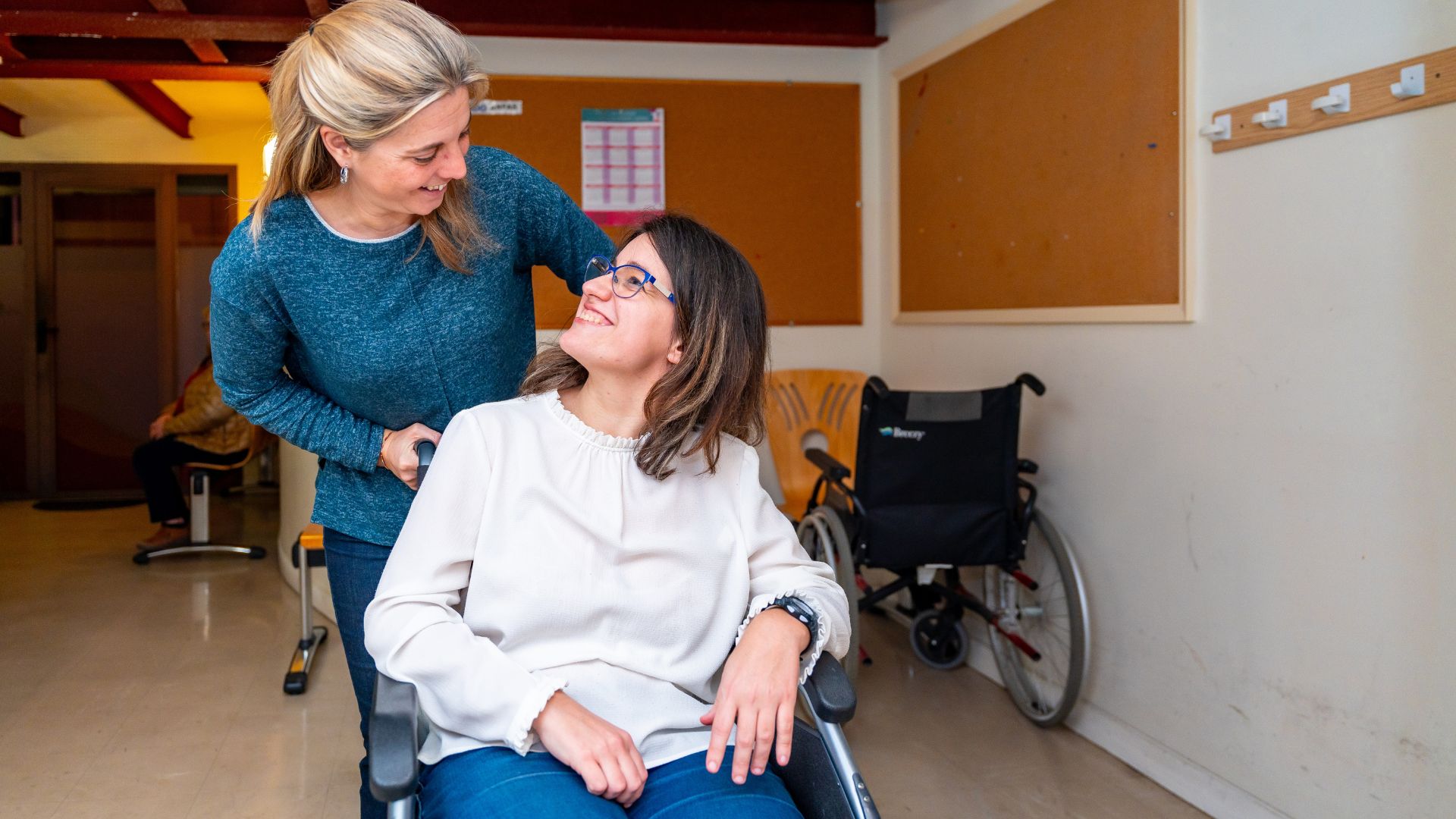 Support worker pushing woman in wheelchair.