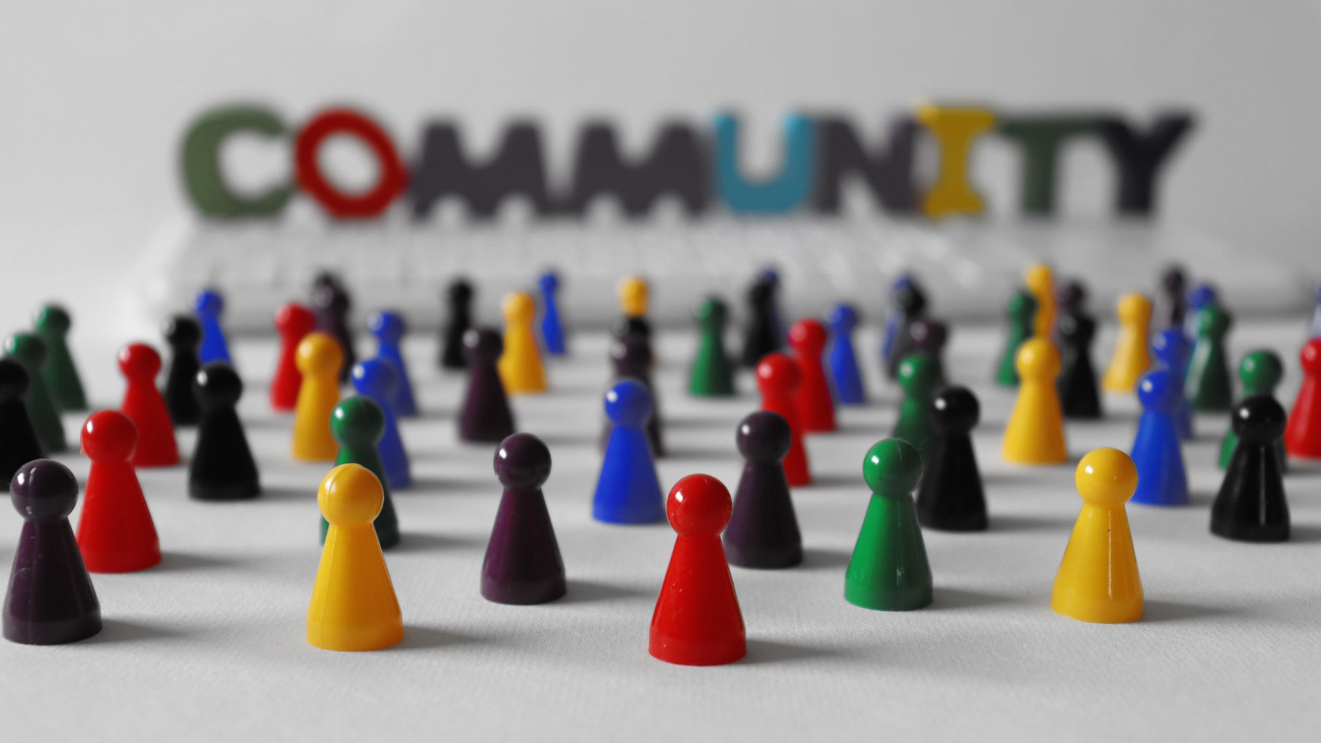Diverse group of colorful game pawns standing tightly.
