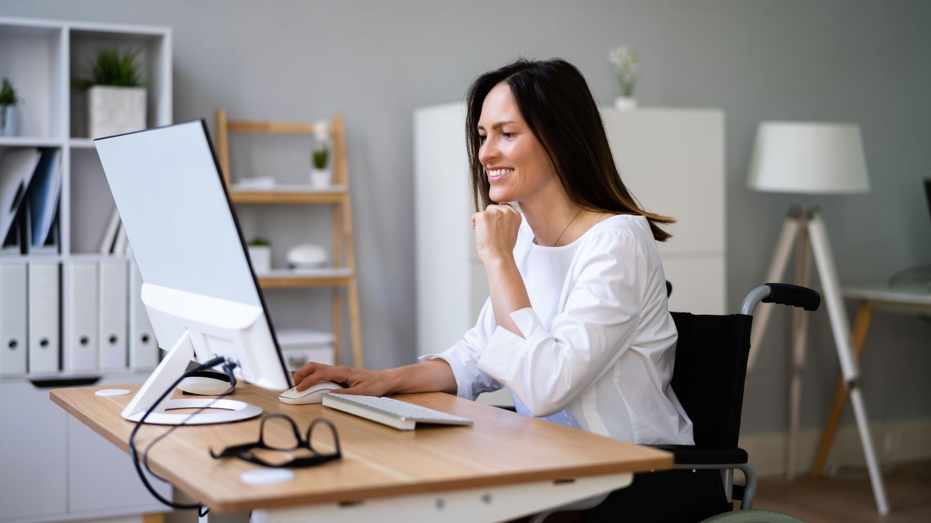 Smiling woman working at computer in an office.